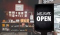 Come in WeÃ¢â¬â¢re OpenÃ¢â¬â¢ on cafe waiter standing in front of coffee shop vintage retro sign Royalty Free Stock Photo